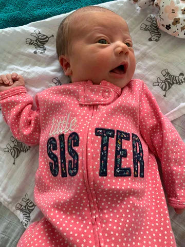 a little baby wearing a little sister zippy