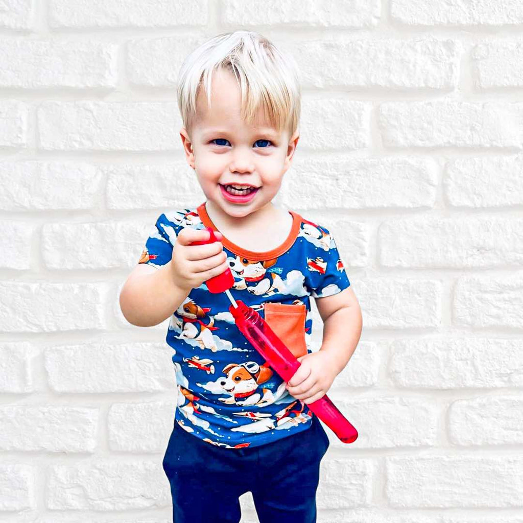 a boy playing with bubbles wearing Paw-some Pilot bamboo shirt featuring dogs flying planes