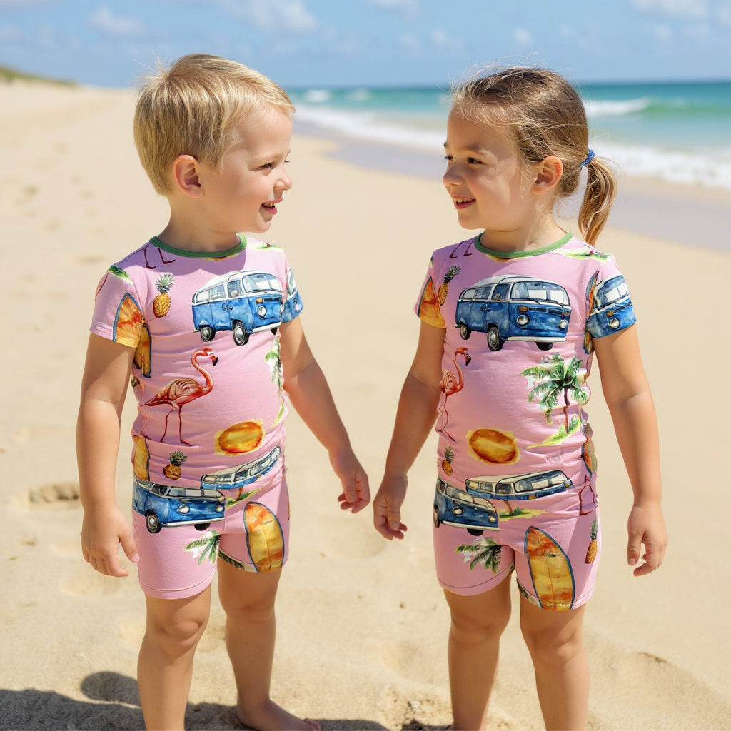 A boy and girl looking at each other wearing identical beach themed pajamas.