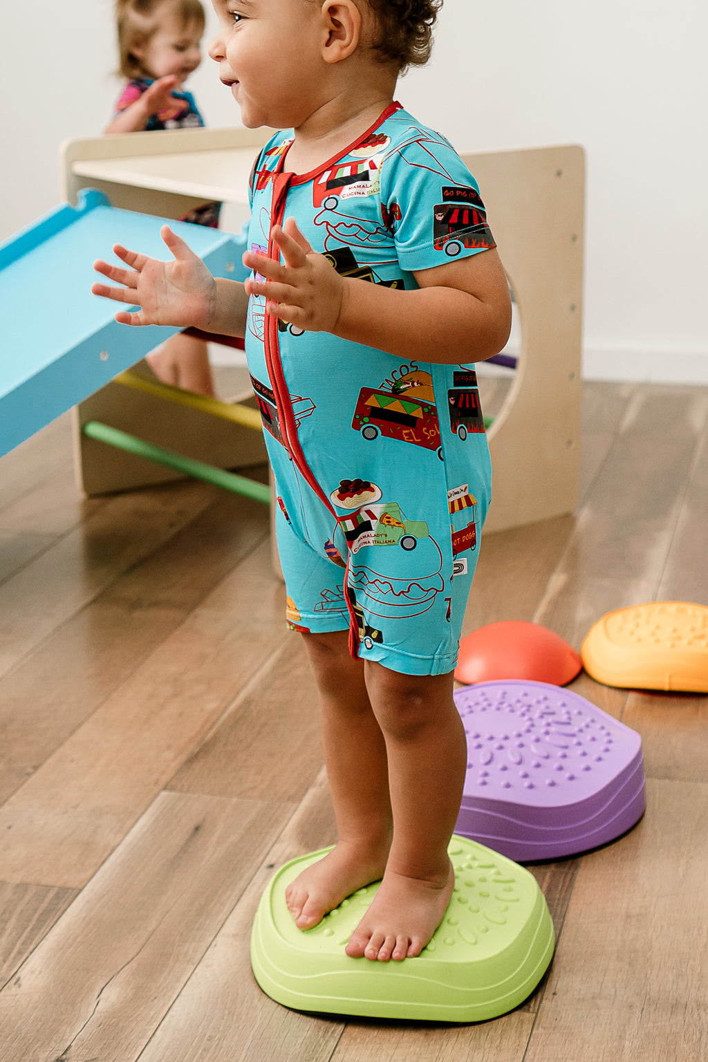 a young  boy playing on colorful stepping stones and wearing Foodie Fun bamboo zippy