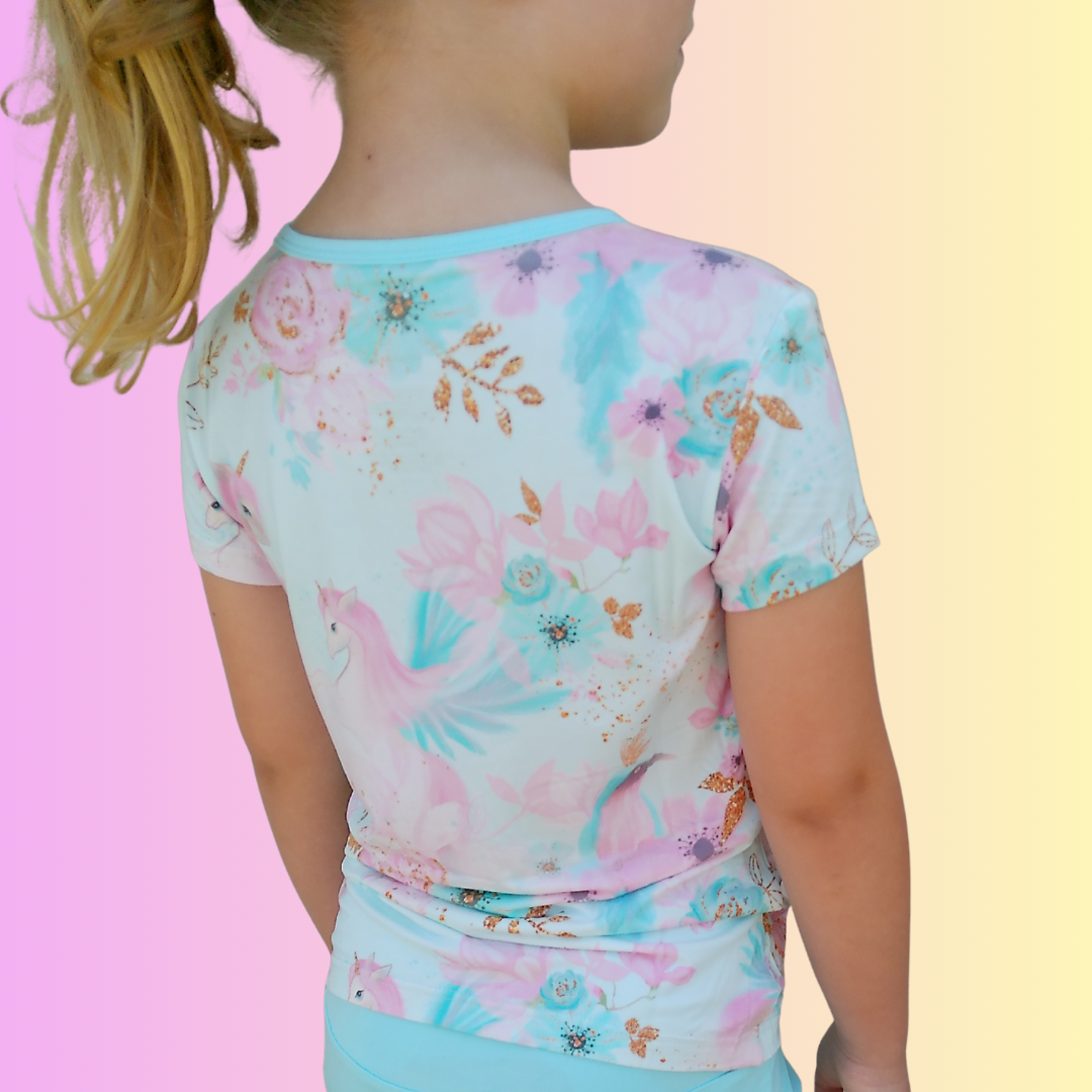 Child wearing Pastel Ponies bamboo shirt featuring a softly colored unicorn and flowers