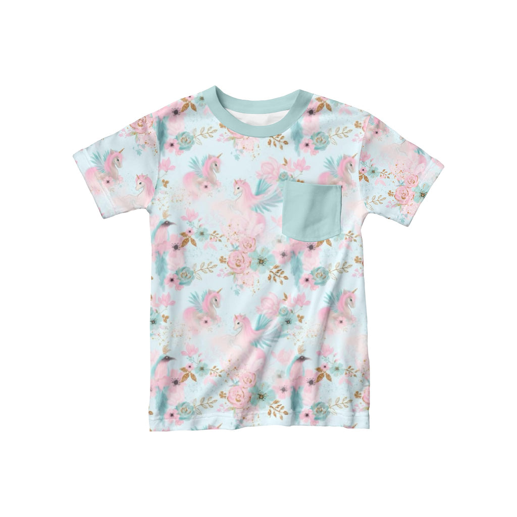 Children’s bamboo t-shirt featuring pastel unicorns, flowers, and birds on a soft background, with a coordinating pastel front pocket, laid flat.
