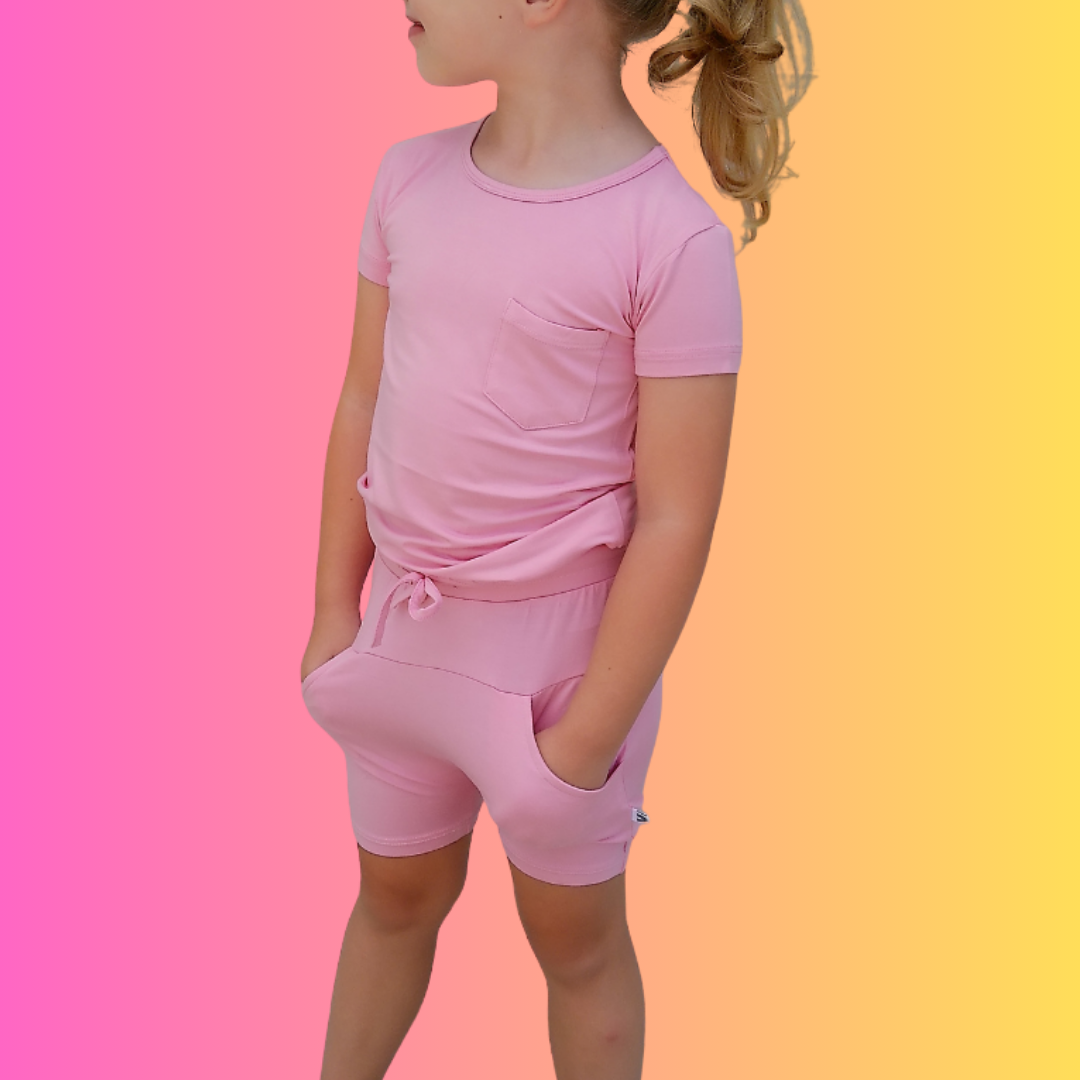 Little girl in a breathable Pink Lemonade bamboo shirt, with a pink gradient background