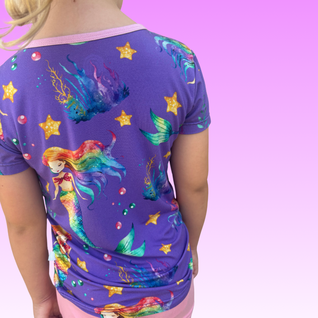 Young girl wearing a Rainbow Reef bamboo shirt with tropical print