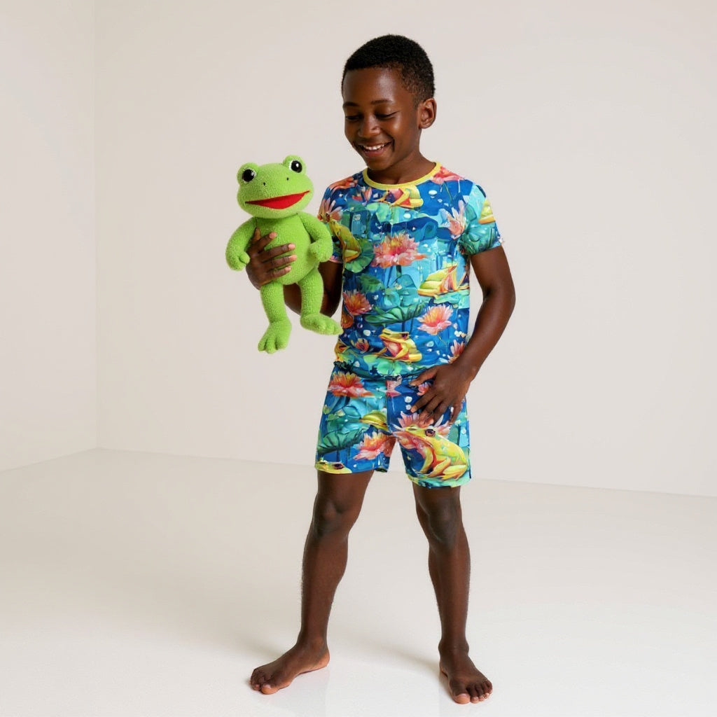 boy holding a stuffed frog while wearing frog bamboo pajamas