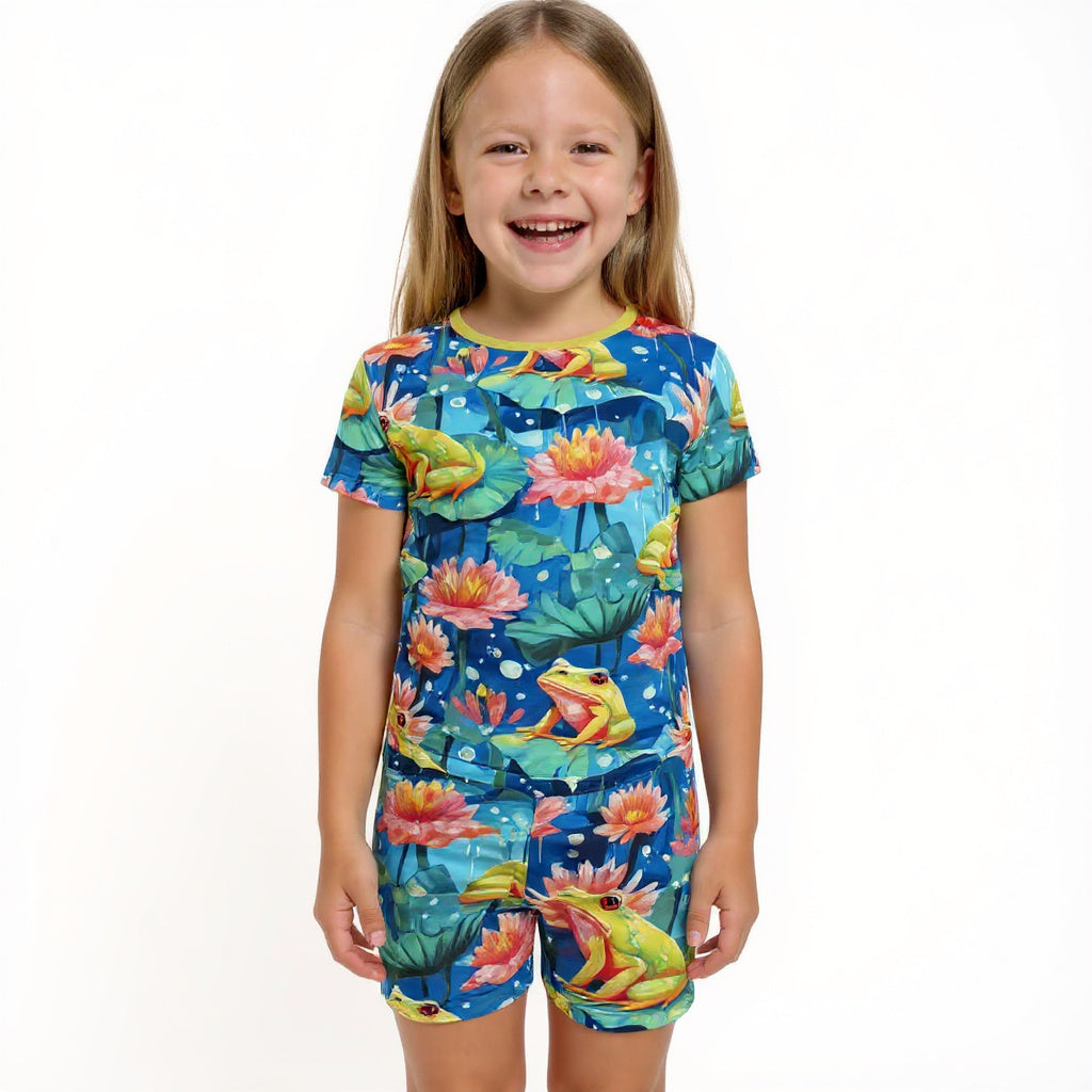 young girl smiling for a picture wearing frog bamboo pajamas