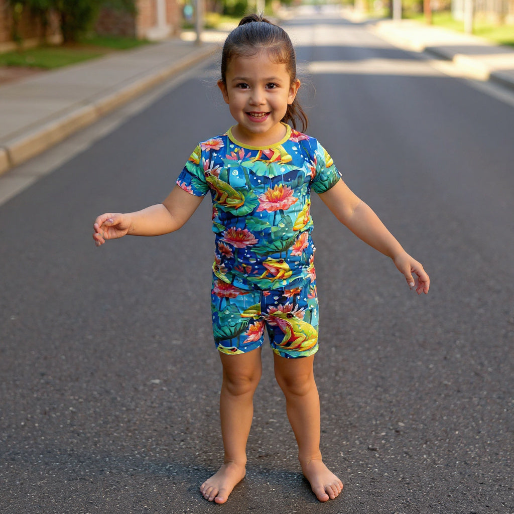 young girl wearing frog two piece pajamas standing in the street